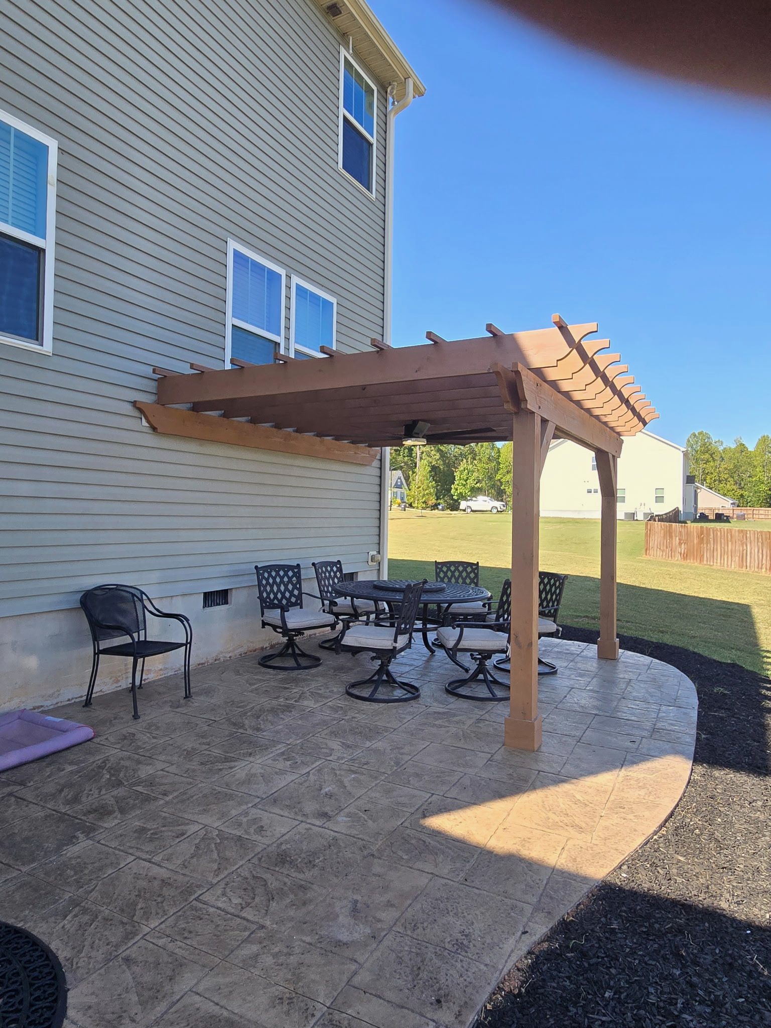 Custom cedar pergola over stamped-concrete patio
